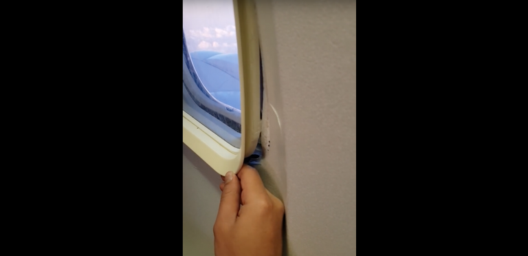 Un pasajero muestra su ventanilla rota en pleno vuelo